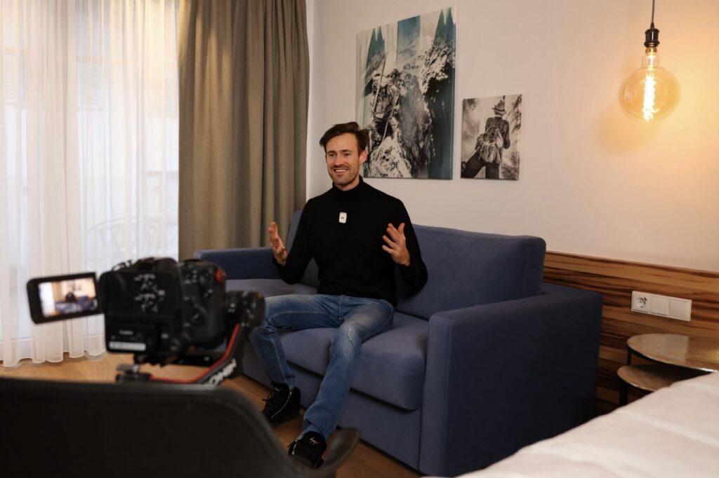 HYLA Vertriebspartner Michael Reiser sitzt auf einem Sofa und schaut in eine Kamera